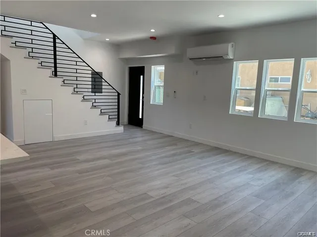 an entryway in a hall with a window and wooden floor