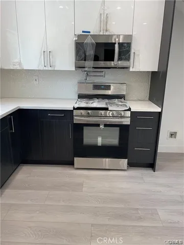 a kitchen with stainless steel appliances a stove a microwave and cabinets