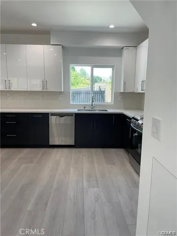 a large kitchen with granite countertop a stove a sink and a microwave