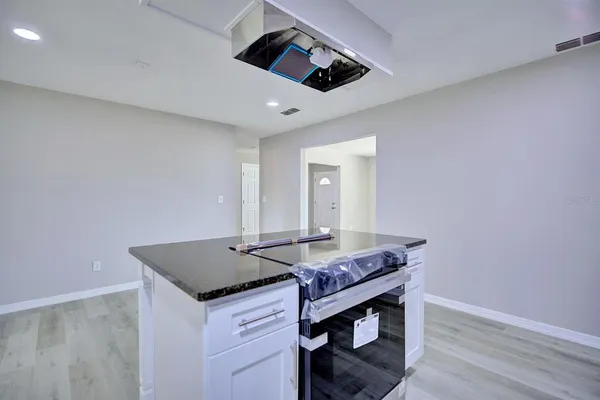 a room with wooden floor and ceiling fan