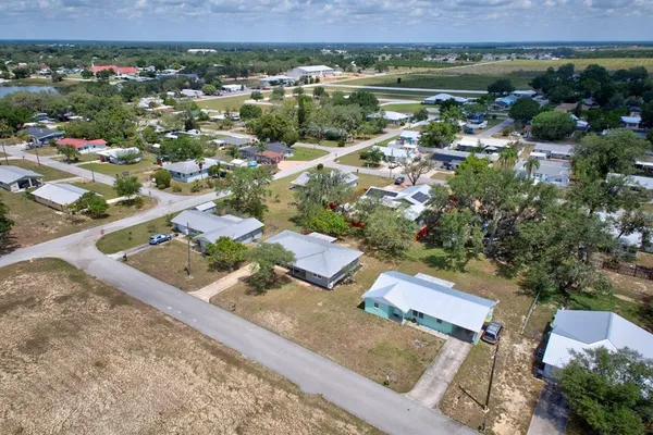 an aerial view of residential houses with outdoor space and river