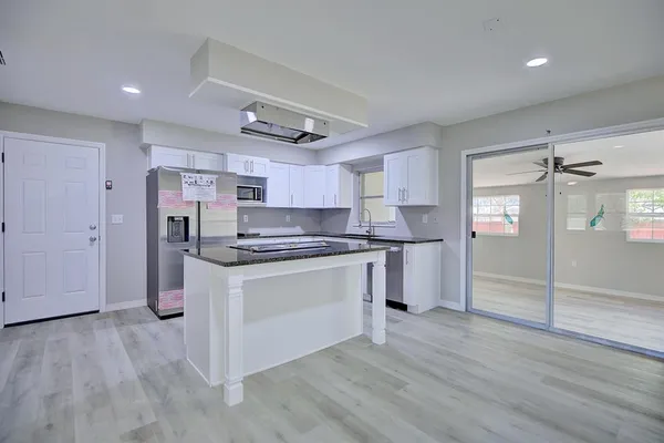 a kitchen with stainless steel appliances granite countertop a refrigerator and a stove top oven