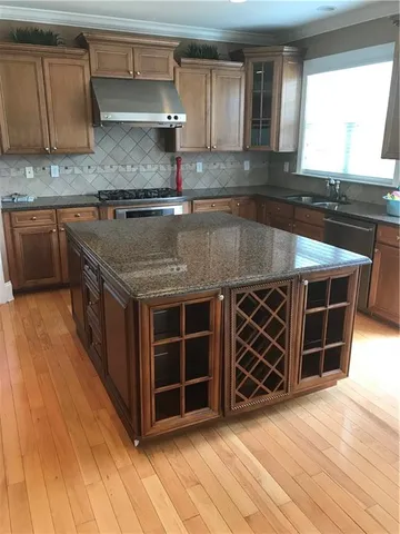 a kitchen with stainless steel appliances granite countertop a sink and a wooden cabinets