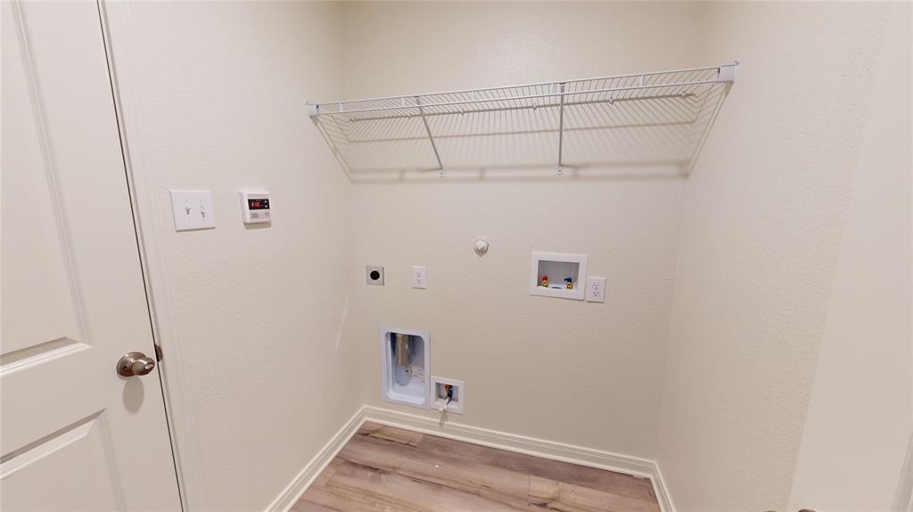 8012 White Sulphur Road Ponder, TX 76259 - Photo 15 of 39 Laundry room featuring hookup for a gas dryer, washer hookup, light wood-style floors, and electric dryer hookup