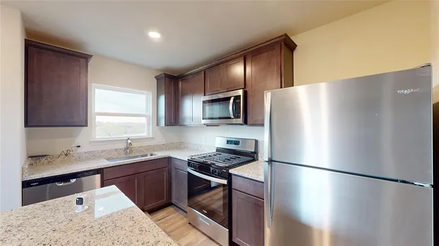 a kitchen with a sink a stove a refrigerator and cabinets