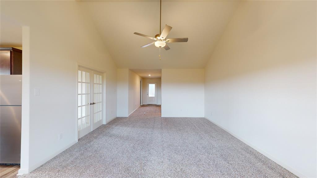 8012 White Sulphur Road Ponder, TX 76259 - Photo 26 of 39 Unfurnished room with high vaulted ceiling, light carpet, a ceiling fan, and french doors