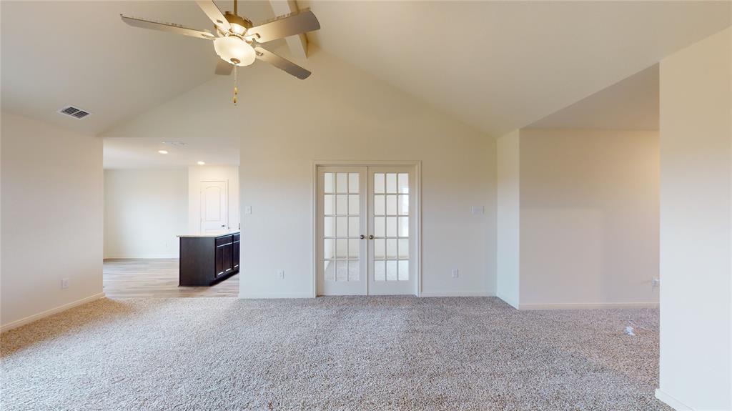8012 White Sulphur Road Ponder, TX 76259 - Photo 28 of 39 Spare room featuring french doors, light colored carpet, beam ceiling, ceiling fan, and high vaulted ceiling
