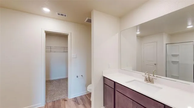 a bathroom with a toilet a sink a mirror and vanity