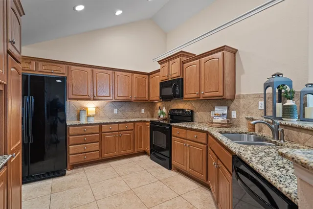 a kitchen with stainless steel appliances granite countertop a sink and cabinets