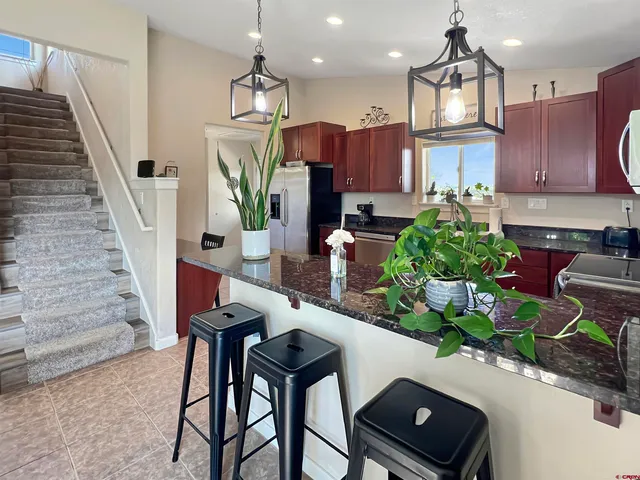 a kitchen with stainless steel appliances granite countertop a refrigerator and a sink