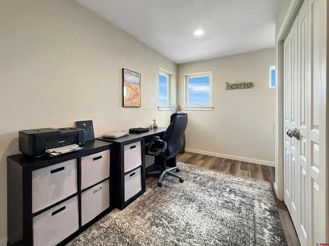 a view of workspace with wooden floor and windows