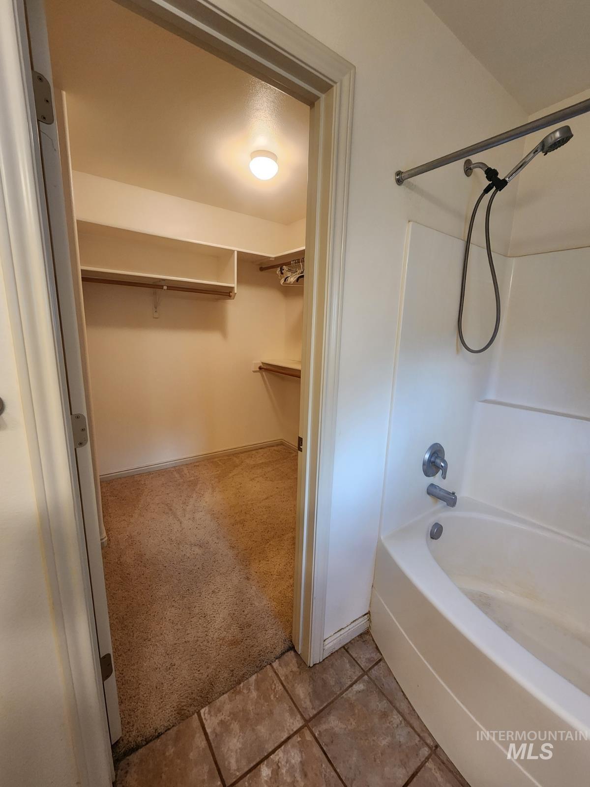 1000 North Rodeo Street Parma, ID 83660 - Photo 12 of 33 Full bathroom featuring a walk in closet, shower / washtub combination, light colored carpet, and light tile patterned floors