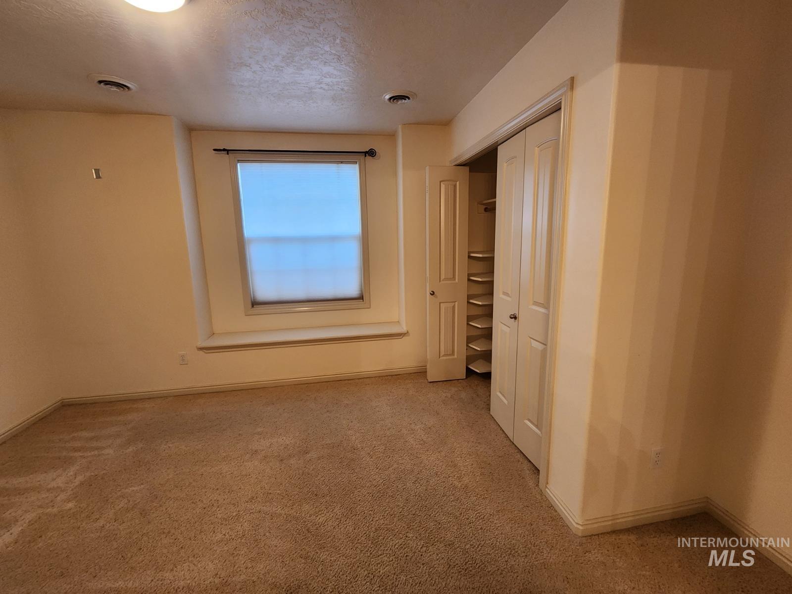 1000 North Rodeo Street Parma, ID 83660 - Photo 16 of 33 Spare room featuring light colored carpet and a textured ceiling