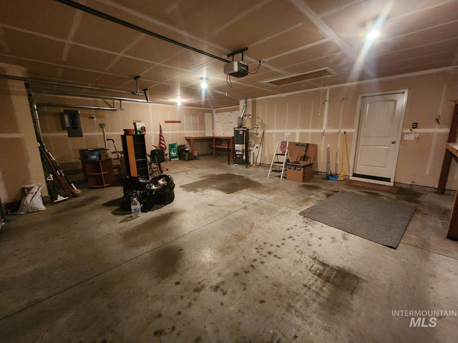 1000 North Rodeo Street Parma, ID 83660 - Photo 24 of 33 Garage with electric panel, a garage door opener, and water heater