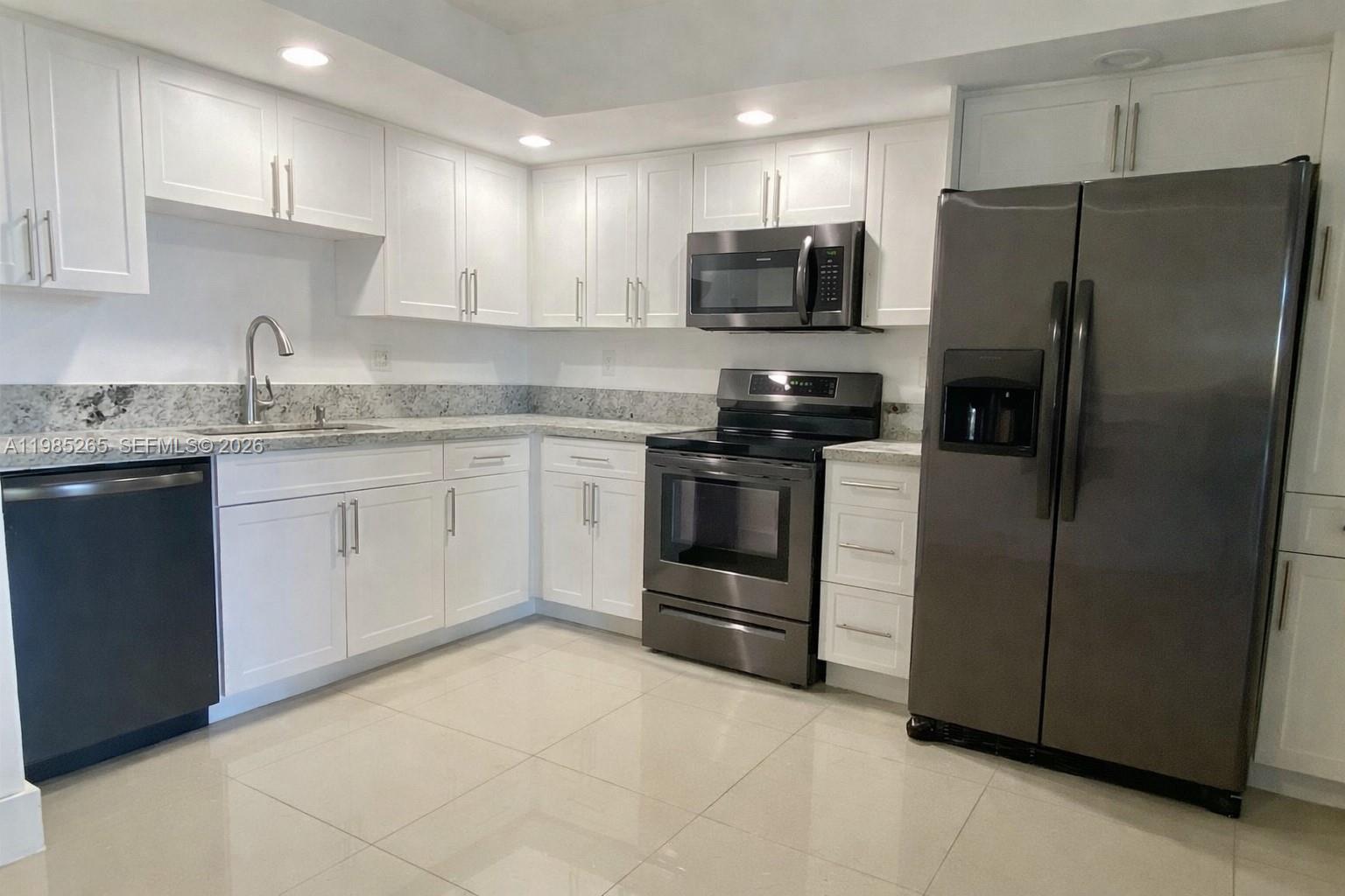 a kitchen with stainless steel appliances granite countertop a refrigerator stove a sink and dishwasher
