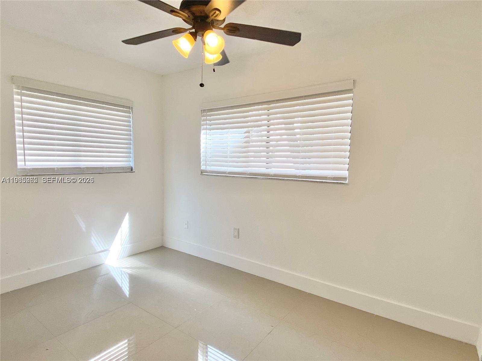8520 Southwest 133rd Avenue Road, Unit 112 Miami, FL 33183 - Photo 6 of 11 en empty room with windows and fan