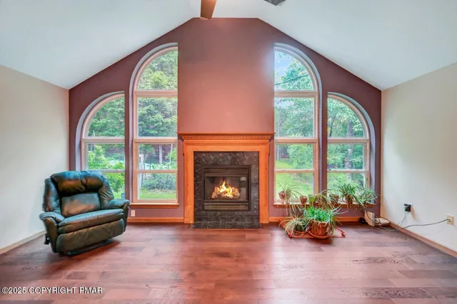 a kitchen with stainless steel appliances granite countertop a refrigerator a stove top oven a sink dishwasher and white cabinets with wooden floor