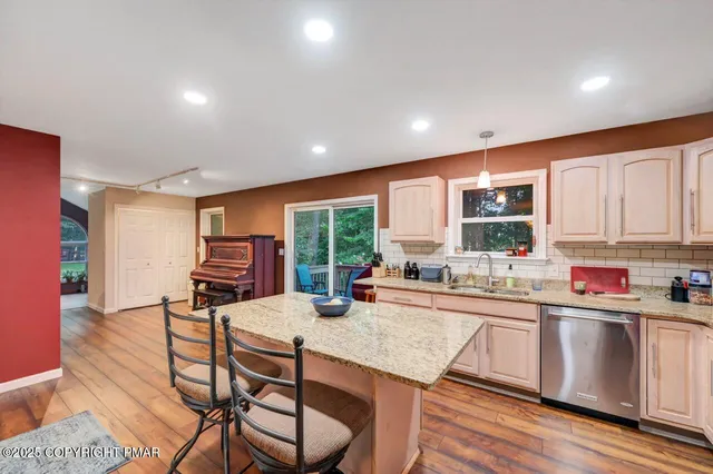 a view of a hallway with wooden floor and furniture
