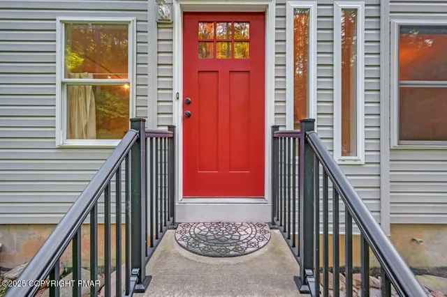 a view of an empty room with furniture a fireplace and a large window