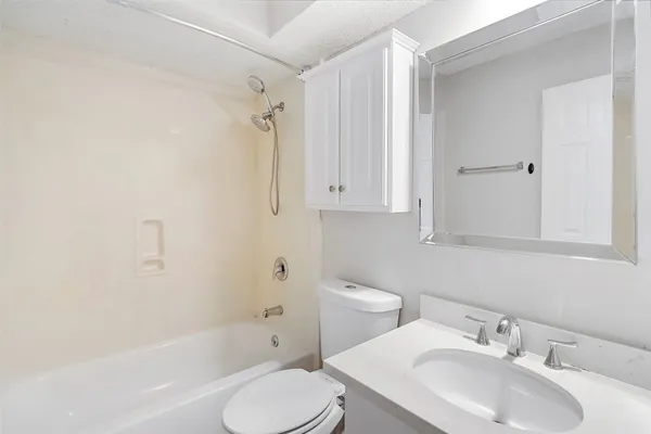 a bathroom with a tub sink and mirror