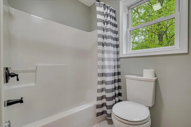 a white toilet sitting next to a bath tub