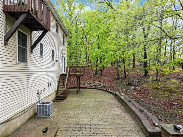 a view of a house with a big yard plants and large trees