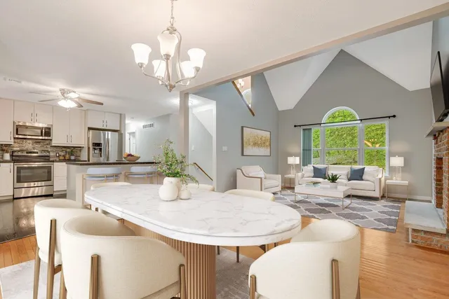 a view of a dining room with furniture a chandelier and wooden floor
