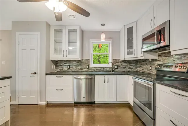 a kitchen with stainless steel appliances granite countertop a stove and a sink