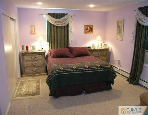 630 Myrtle Road North Brunswick, NJ 08902 - Photo 4 of 8 a bedroom with a bed and a mirror on dresser