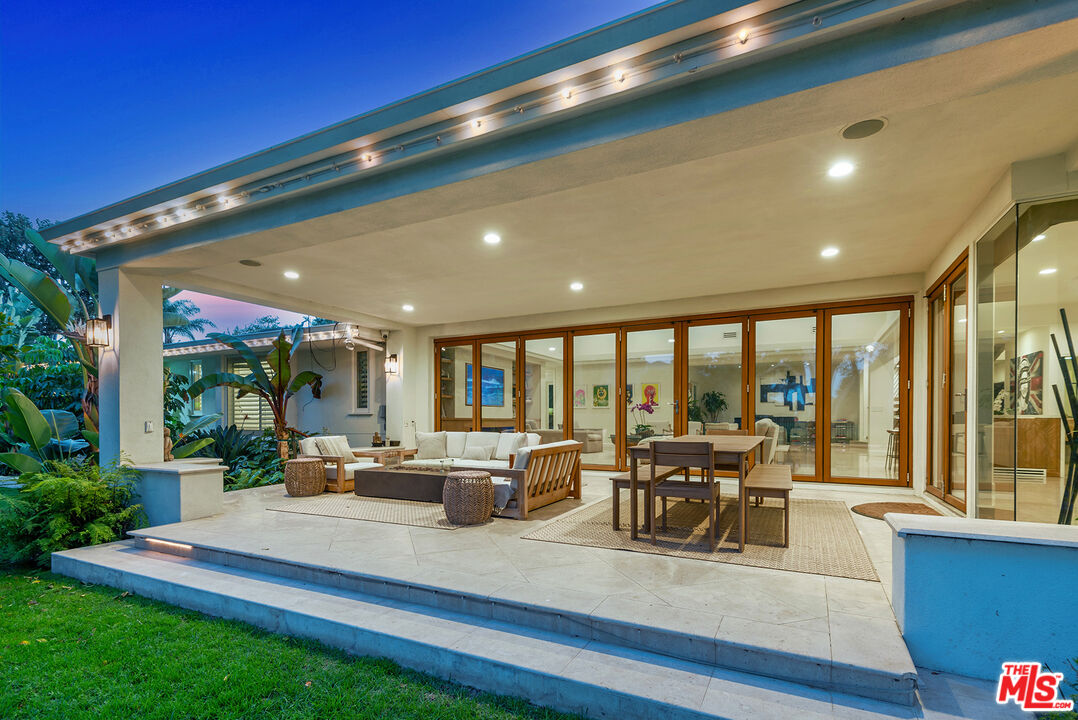10424 Valley Spring Lane Toluca Lake, CA 91602 - Photo 19 of 44 a view of a dining room with furniture large windows and wooden floor