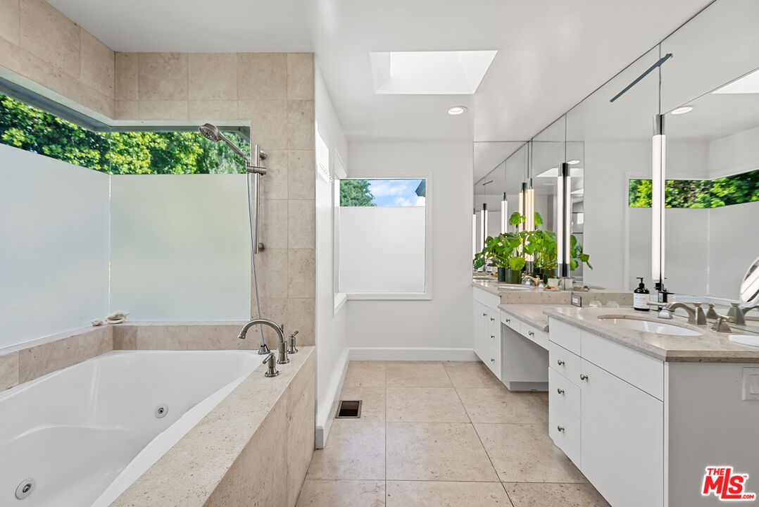 10424 Valley Spring Lane Toluca Lake, CA 91602 - Photo 38 of 44 a bathroom with a bathtub a sink a mirror and a shower