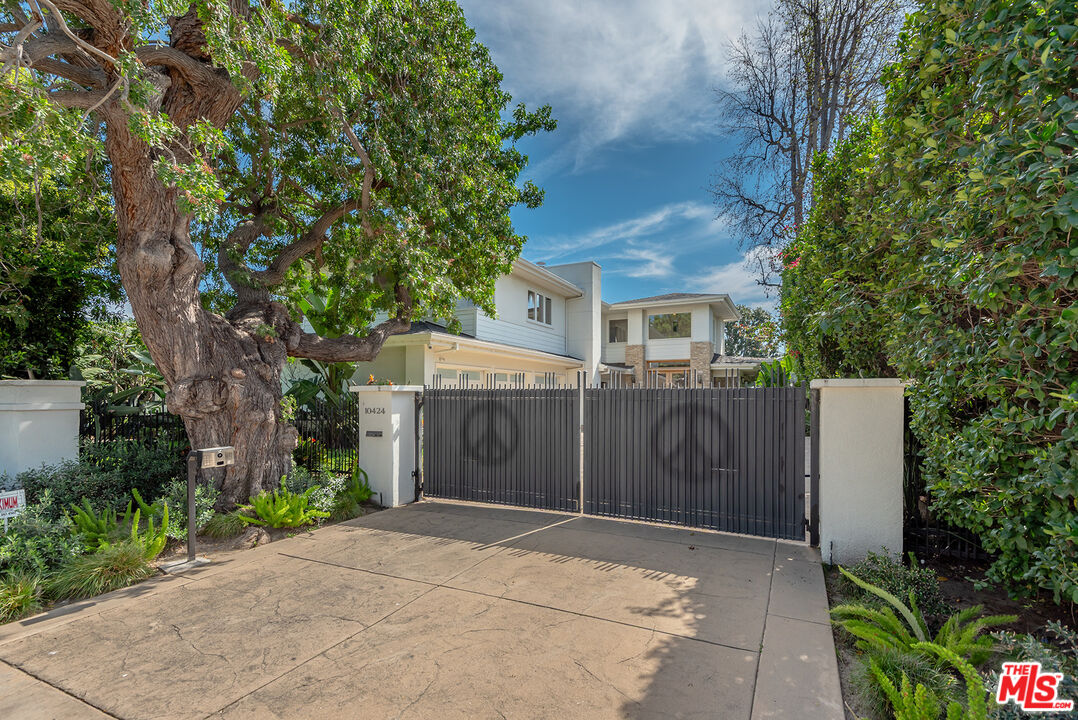10424 Valley Spring Lane Toluca Lake, CA 91602 - Photo 44 of 44 a view of a white house with a large tree and plants