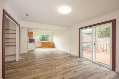 a view of empty room with wooden floor and floor to ceiling window