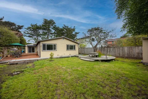 a view of a house with backyard and sitting area