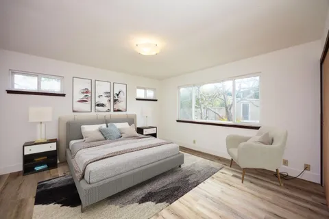 a bedroom with a bed and a large window