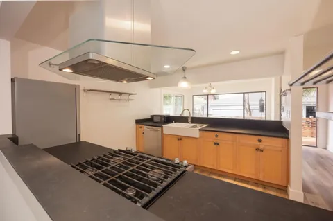a kitchen with stainless steel appliances granite countertop a sink stove and refrigerator