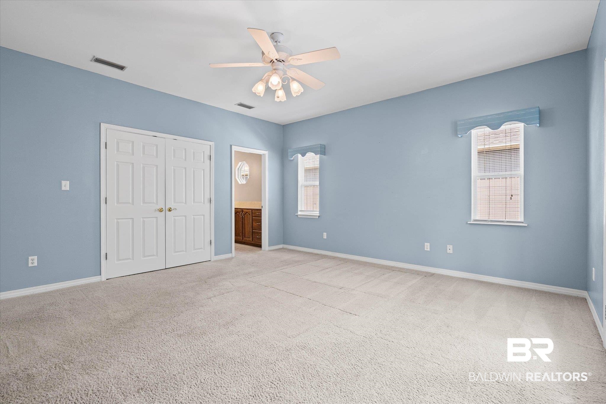 41923 Bayou Road Bay Minette, AL 36507 - Photo 13 of 35 Spacious carpeted room featuring a ceiling fan with light fixture, two double-hung windows, and bifold closet doors