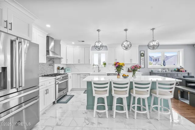 a kitchen with granite countertop stainless steel appliances a stove a sink a dining table and chairs