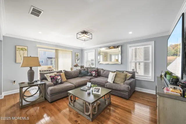 a living room with furniture a flat screen tv and a window
