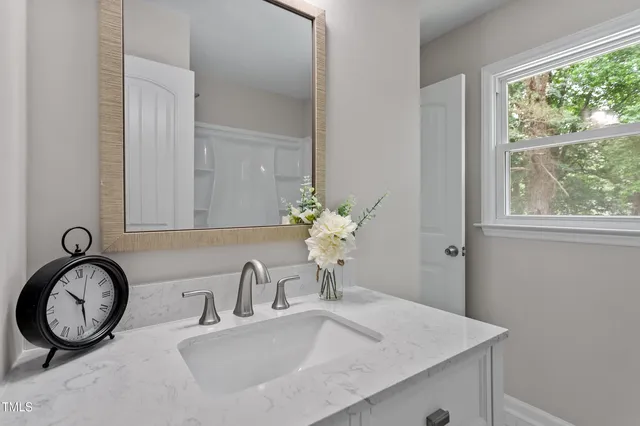 a bathroom with a granite countertop sink and a mirror