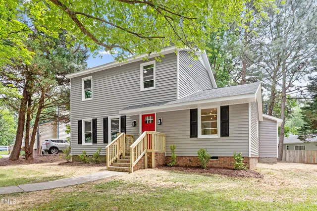 a view of a house with a patio and a yard
