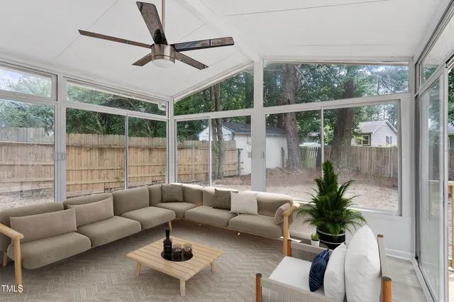 a living room with furniture a ceiling fan and a window