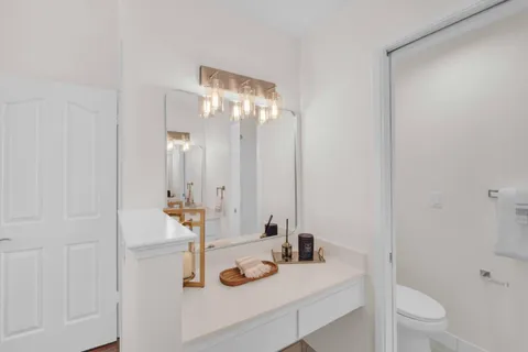 a bathroom with a sink toilet vanity and shower