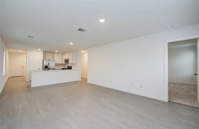 a view of a kitchen with kitchen island and stainless steel appliances