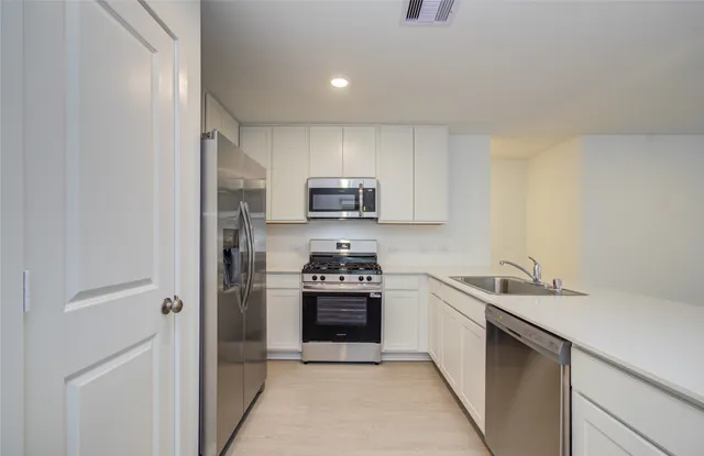 a kitchen with a sink cabinets and stainless steel appliances