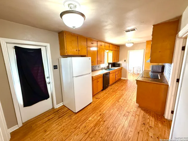 a kitchen with cabinets a refrigerator and a stove