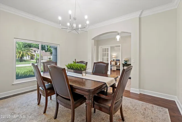 a view of a dining room with furniture a chandelier and wooden floor