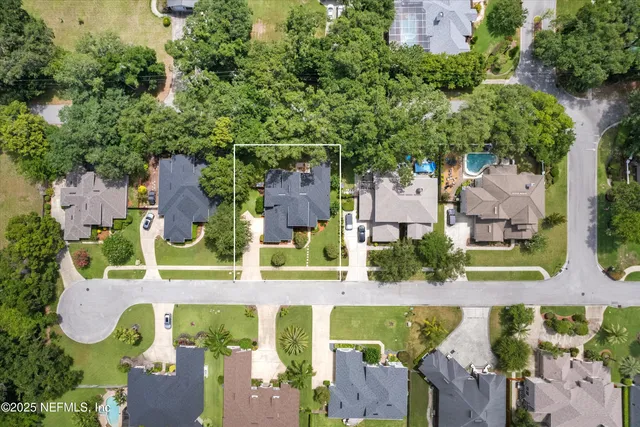 an aerial view of residential houses with outdoor space and street view