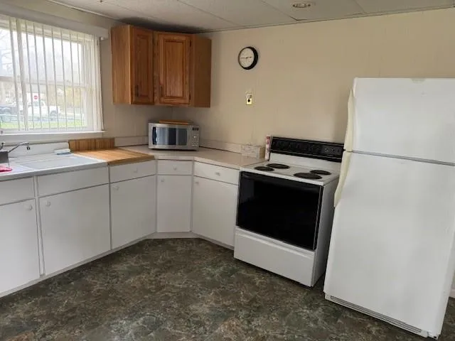 a kitchen with a stove sink and white cabinets