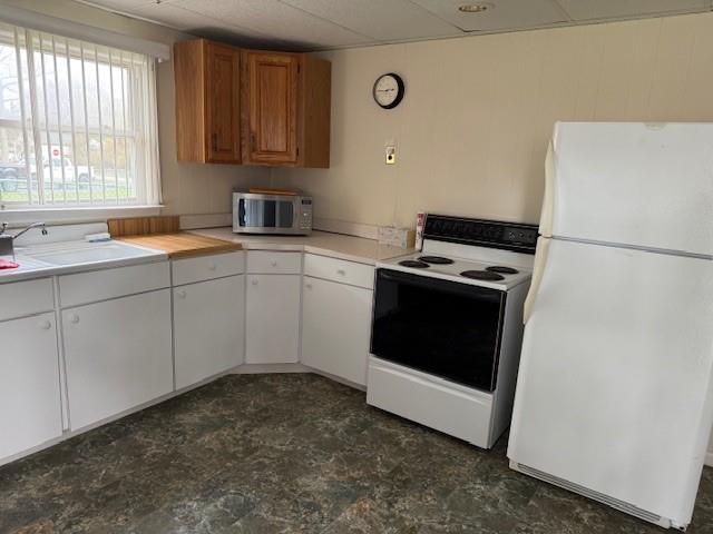 128 Maywood Road Mastic Beach, NY 11951 - Photo 6 of 11 a kitchen with a stove sink and white cabinets